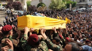 Hezbollah fighters in their military uniform, foreground, carry the coffin of Hezbollah fighter Hassan Faisal Shuker, 18, who was killed in a battle against Syrian rebels in the Syrian town of Qusair on Monday May 20 (photo credit: AP)