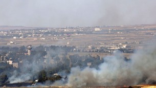 Smoke rises from a fire as a result of fighting in the Syrian village of Quneitra near the border with Israel, as seen from an observatory near the Quneitra crossing, Thursday, June 6, 2013. Syrian rebels on Thursday captured a crossing point along a cease-fire line with Israel in the contested Golan Heights, a development that could deepen Israeli concerns over the growing role of Islamic radicals in the civil war near its northern frontier.(AP Photo/Sebastian Scheiner)