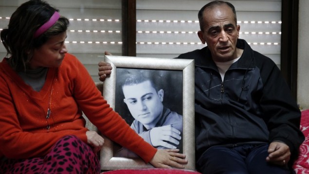 Les parents le 13 février 2015 tenant entre leurs mains le portrait  de Muhammad Said Ismail Musallam qui entre les mains de l'EI (Crédit : AFP PHOTO / THOMAS COEX)