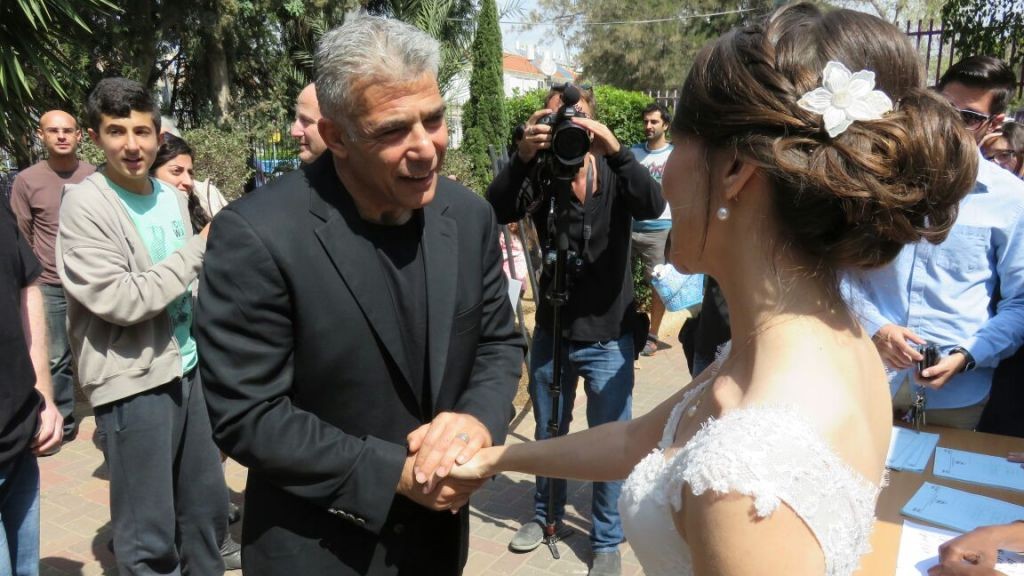 Yesh Atid leader Yair Lapid shakes hands with Victoria, who will marry Gary later on Tuesday. The couple both vote for Yesh Atid and went to vote on their way to their Huppah. (picture credit: Courtesy Yair Lapid) Yesh Atid leader Yair Lapid shakes hands with Victoria, who will marry Gary later on Tuesday. The couple both vote for Yesh Atid and went to vote on their way to their Huppah. (picture credit: Courtesy Yair Lapid)