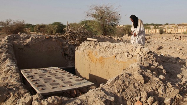 In this Friday, April 4, 2014 file photo, Mohamed Maouloud Ould Mohamed, a mausoleum caretaker, prays at a damaged tomb in Timbuktu, Mali. (AP Photo/Baba Ahmed, File)