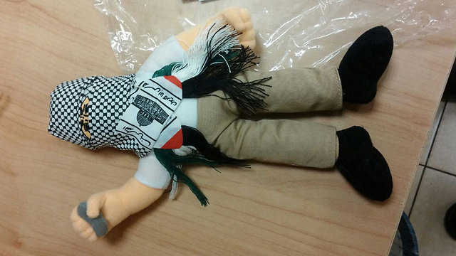 A doll wearing a kufiyah and holding a stone, part of a shipment of 4,000 such dolls intercepted by Haifa customs. They were meant to be sold in Palestinian markets. (Haifa customs) A doll wearing a kufiyah and holding a stone, part of a shipment of 4,000 such dolls intercepted by Haifa customs. They were meant to be sold in Palestinian markets. (Haifa customs)