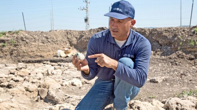 Le directeur des fouilles Abdel Al-Salam Said, examine l'un des morceaux de verre retrouvé dans la zone de fouille. (Crédit : Shmuel Magal, autorisation de l'Autorité israélienne des Antiquités)