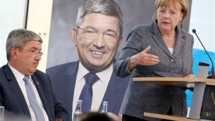 German Chancellor Angela Merkel speaks alongside Lorenz Caffier, left, of Merkel's Christian Democrats, during an election campaign in Neustrelitz, Germany on Aug. 17, 2016. (Bernd Wuestneck/dpa via AP)