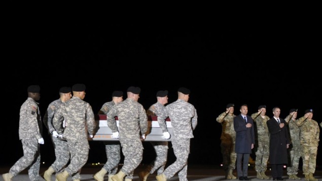 In this Monday, November 7, 2016 file photo, an Army carry team moves a transfer case containing the remains of Sgt. 1st Class Matthew C. Lewellen past Army Secretary Eric Fanning, fifth from right, Undersecretary of Defense for Intelligence Marcel Lettre, third from right, and Gen. Daniel B. Allyn, right, Army vice chief of staff, at Dover Air Force Base, Delaware. 