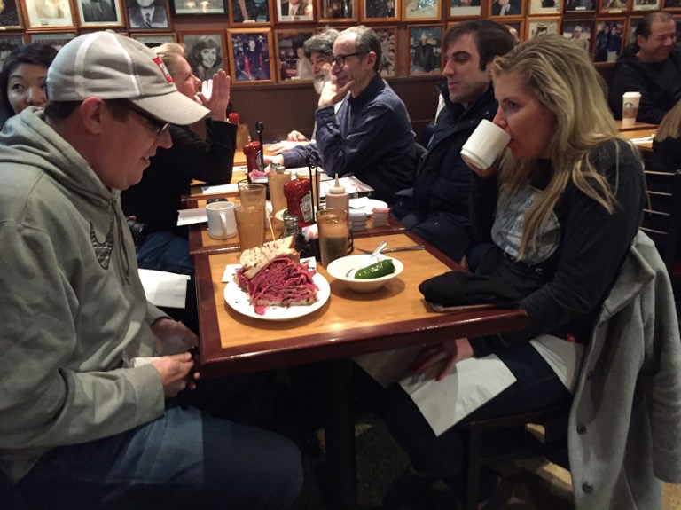 New Yorker Paul Zatek (L) waits to take his first bite of a "Woody Allen" pastrami sandwich at the Carnegie Deli December 30, 2016 in New York. The deli will close after 79 years of service on December 30. (AFP PHOTO / Catherine Triomphe)