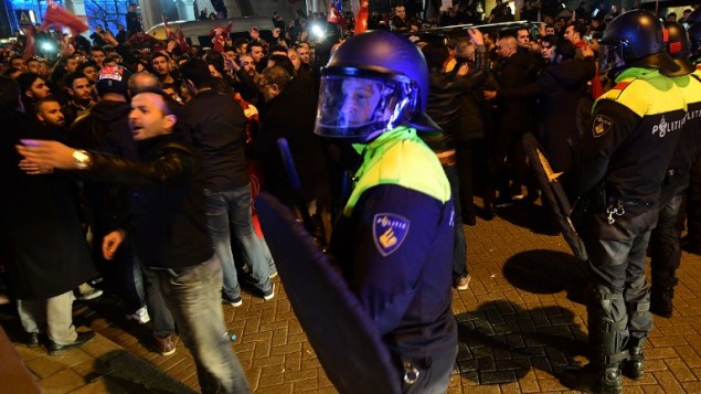 Police officers face protesters gathered outside Turkey's consulate in Rotterdam on March 11, 2017. (AFP PHOTO / EMMANUEL DUNAND)
