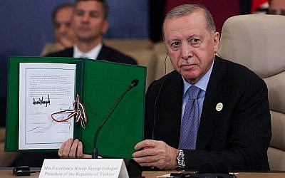 شرح عکس:‌ رجب طیب اردوغان رئیس جمهوری ترکیه، بعد از قرارداد آتش بس، در حمایت از جنگ دو سالهٔ اسرائیل-حماس در غزه، در نشست ۱۳ اکتبر ۲۰۲۵ در شرم الشیخ، مصر، سند امضا شده ای را بالا گرفته است.
(Suzanne Plunkett/Pool via AP)