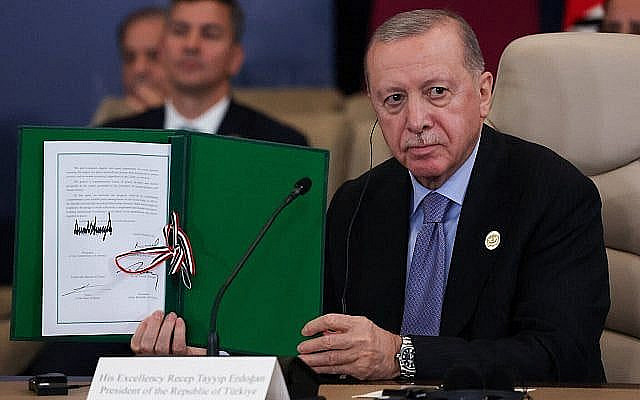 شرح عکس:‌ رجب طیب اردوغان رئیس جمهوری ترکیه، بعد از قرارداد آتش بس، در حمایت از جنگ دو سالهٔ اسرائیل-حماس در غزه، در نشست ۱۳ اکتبر ۲۰۲۵ در شرم الشیخ، مصر، سند امضا شده ای را بالا گرفته است.
(Suzanne Plunkett/Pool via AP)