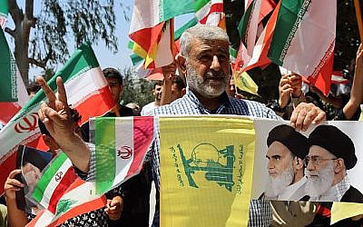 شرح عکس: حامیان در تظاهراتی به هواداری ایران در جنوب لبنان،‌۲۹ ژوئن ۲۰۲۵، پرچم های ایران، لبنان و حزب الله را تکان می دهند. Shutterstock