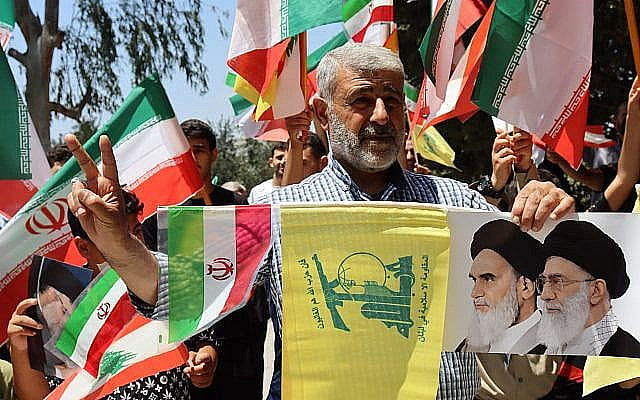 شرح عکس: حامیان در تظاهراتی به هواداری ایران در جنوب لبنان،‌۲۹ ژوئن ۲۰۲۵، پرچم های ایران، لبنان و حزب الله را تکان می دهند. Shutterstock