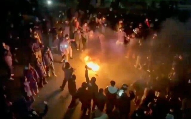 این تصویر که از فیلمی که در شبکه‌های اجتماعی منتشر شده گرفته شده، معترضانی را نشان می‌دهد که در حال رقص و شادی دور آتش هستند و در خیابان‌های تهران، ایران، در ۹ ژانویه ۲۰۲۶ به خیابان‌ها آمده‌اند.
(UGC via AP)